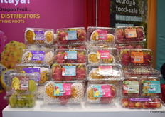 Display of exotic fruit varieties in the Freshway Produce booth. Yellow and white dragon fruit, star fruit, lychee, and longan are part of the selection. 