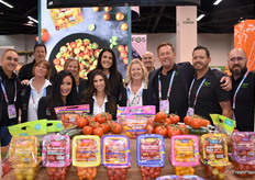 Team Village Farms proudly poses by a colorful display of greenhouse grown tomatoes.