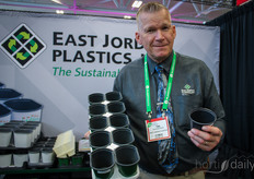 Tim Vaandering is showing a tray with stadium pots, which, because of their shape, saves 15%  space on the bench