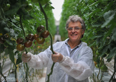Yvo Lens showing Ebeno, a brown round tomato, both loose and on the vine, 110 grams.