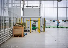 A robot prepares empty harvest trolleys by pushing a new batch with empty harvesting boxes on them.