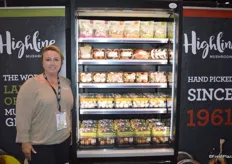 Sabrina Pokomandy with Highline Mushrooms stands next to the cooler that contains several innovative packaging options for mushrooms, including bags and top seal.