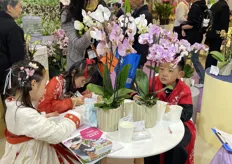 Children in ancient costumes are drawing Phalaenopsis.